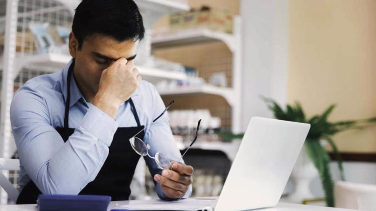 Stressed man holding the bridge of his nose.
