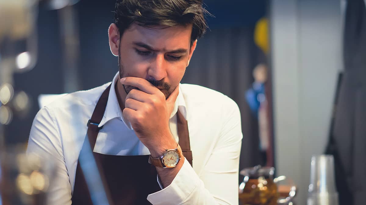 man contemplating paid sick leave laws by state as he reads something and covers his mouth with his hand