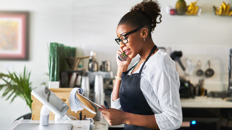 Business owner on the phone looking at a notepad.