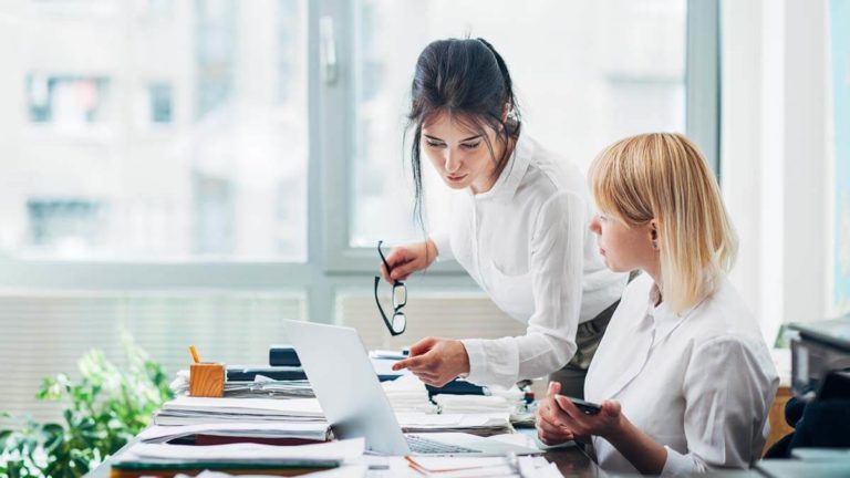 Two women discussing profit margin analysis.