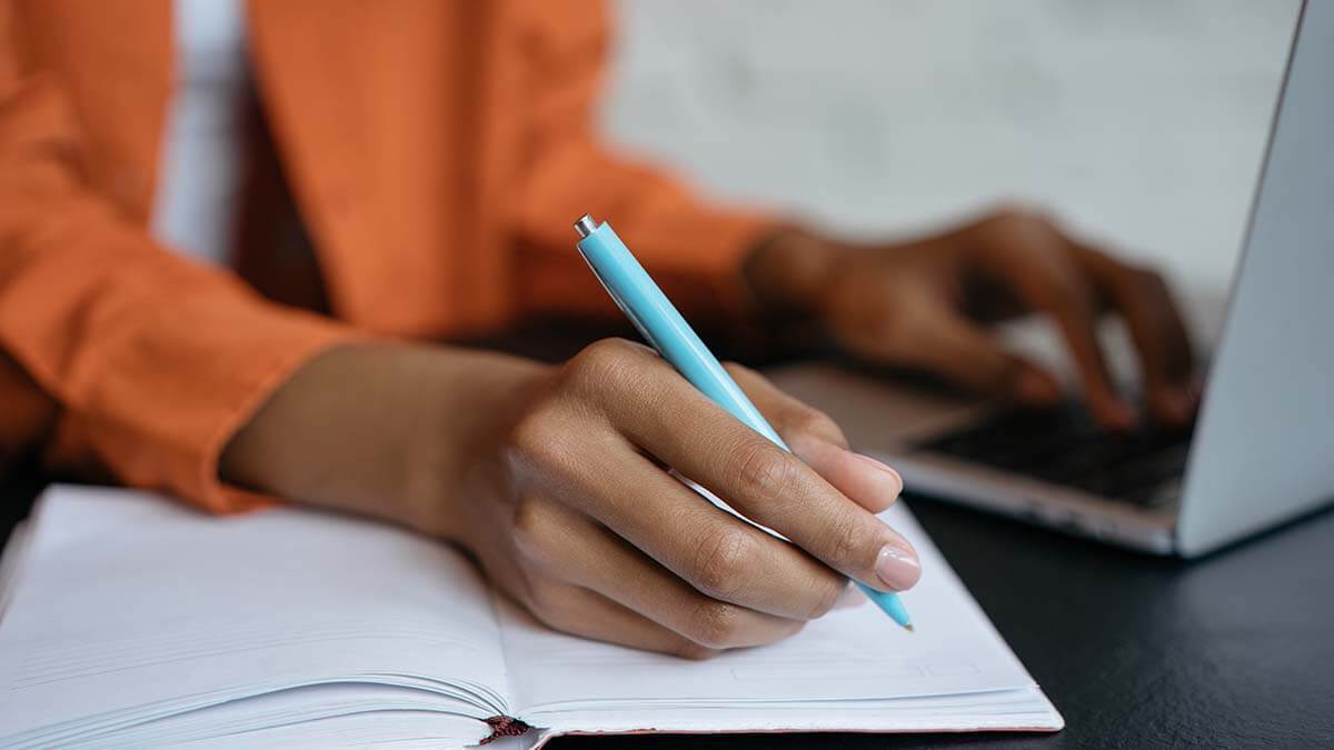 Woman writing with a blue pen.