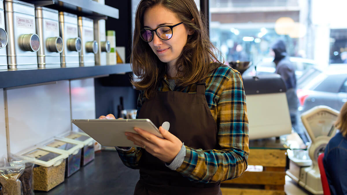 Barista writing on a tablet.