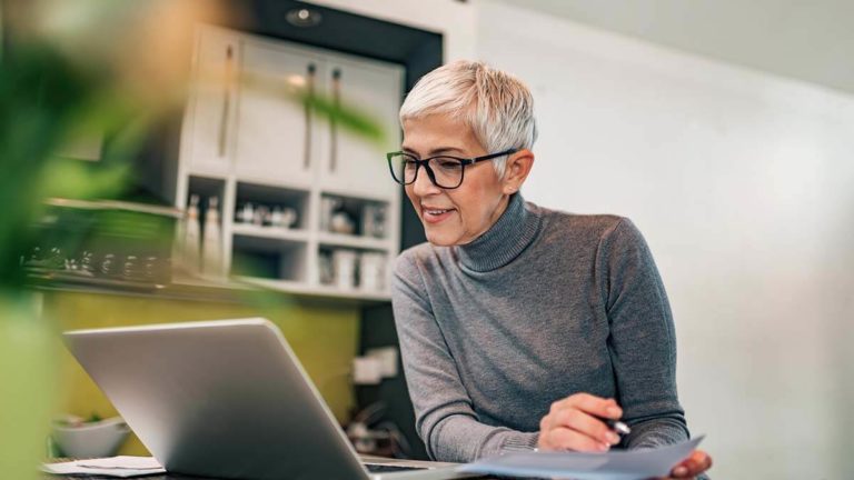 Woman taking a closer look at the small business general ledger.