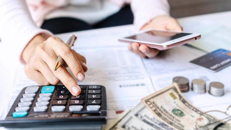 Table with calculator, money, and paperwork.