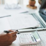 Woman using a calculator at a desk.