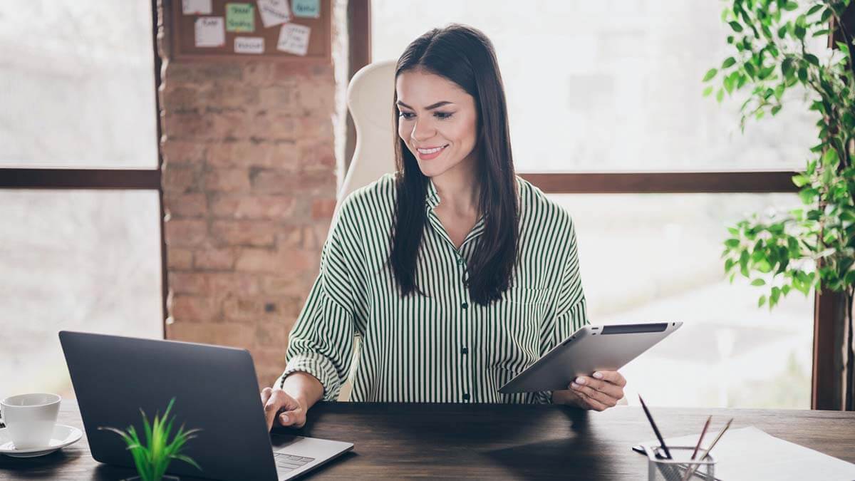 Smiling woman working on a laptop.