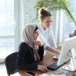 Two women looking at a computer.