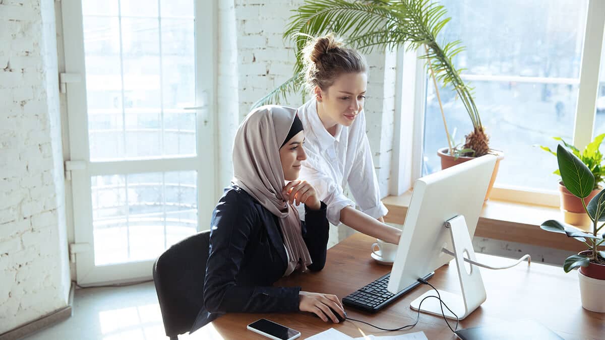 Two women looking at a computer.