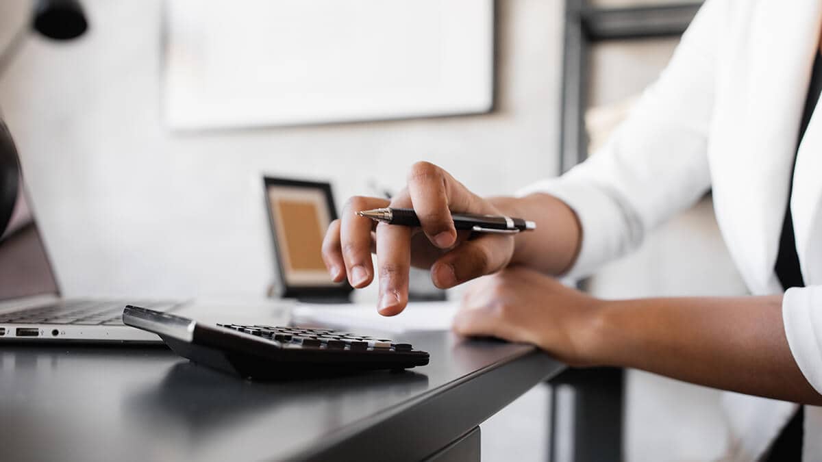 Woman typing on calculator.
