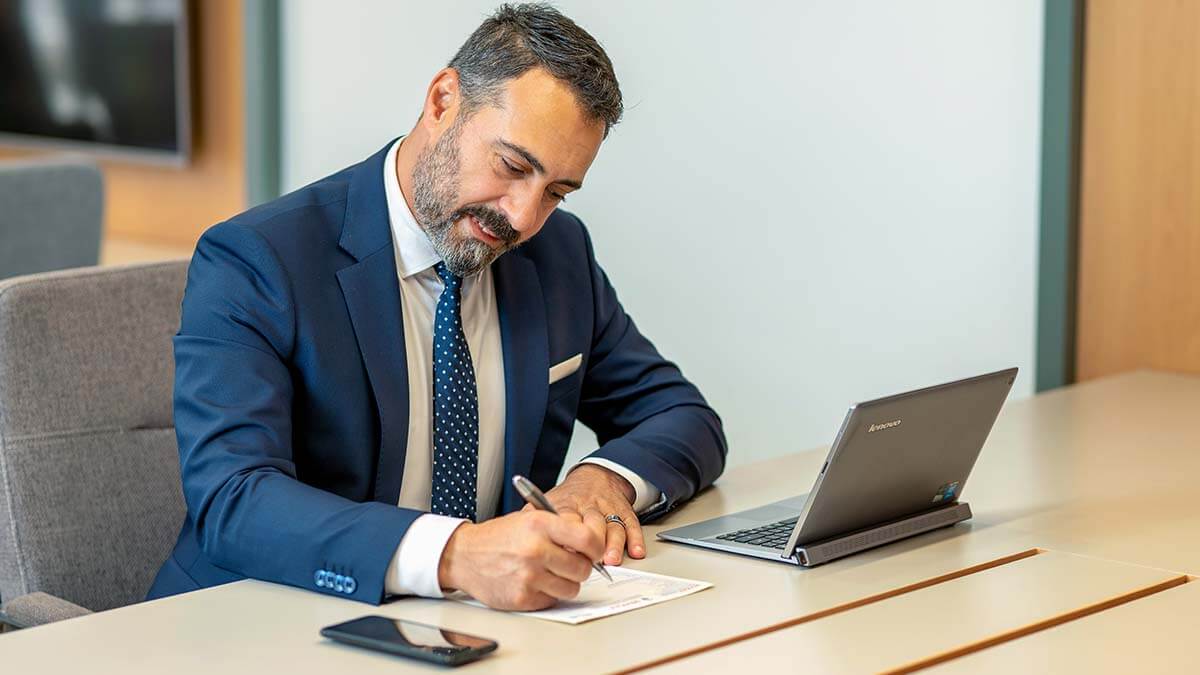 Man sitting at a table, filling out paperwork.