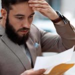Stressed man reviewing wage violations.