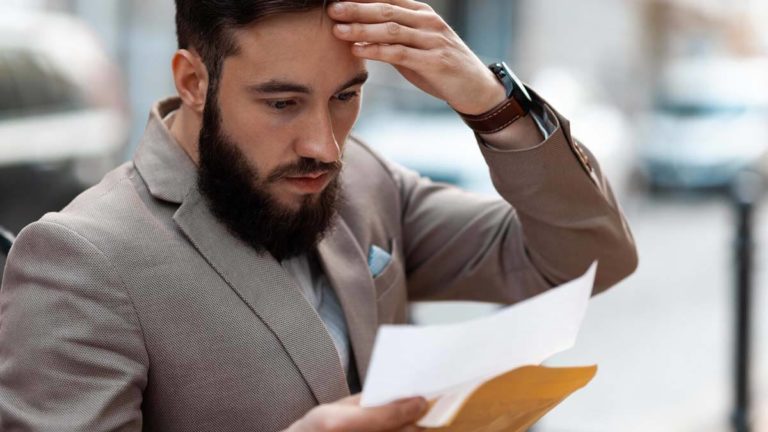 Stressed man reviewing wage violations.