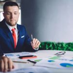 Man in a suit doing paperwork.
