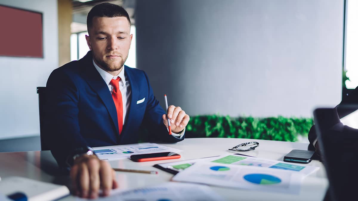 Man in a suit doing paperwork.