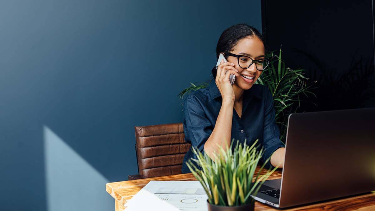 Woman on the phone and using a computer.