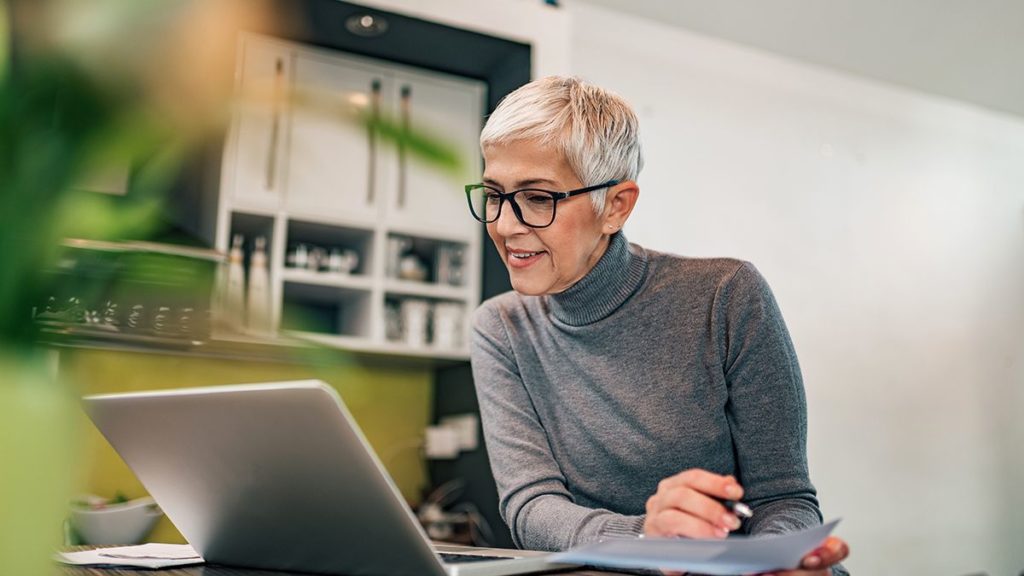 woman looking at laptop screen and analyzing data