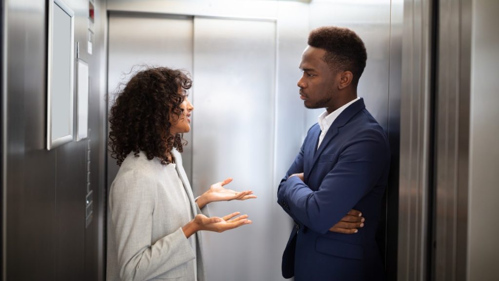 a man and woman stand in an elevator while the woman gives her entrepreneur elevator pitch