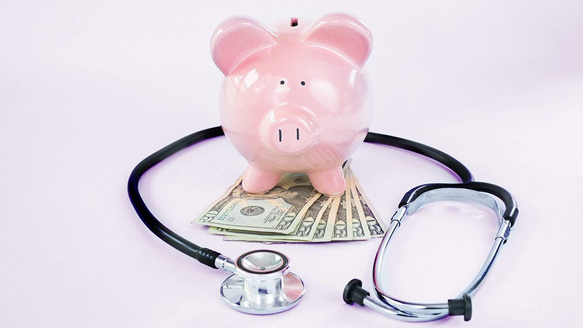 piggy bank surrounded by stethoscope and money