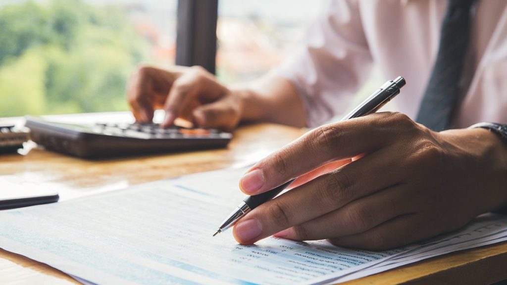 man using calculator and learning how to record accrued interest