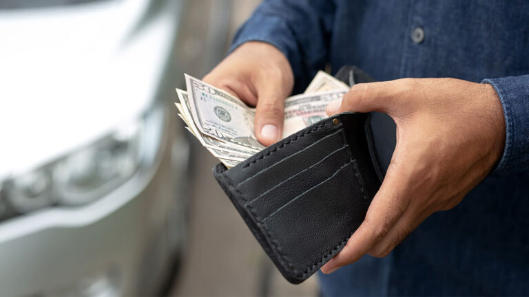 Business owner putting cash in wallet.