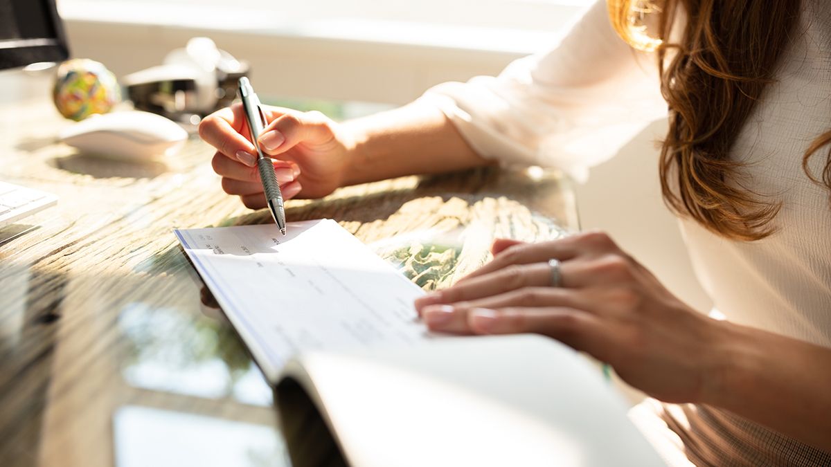 woman holding pen and writing a check