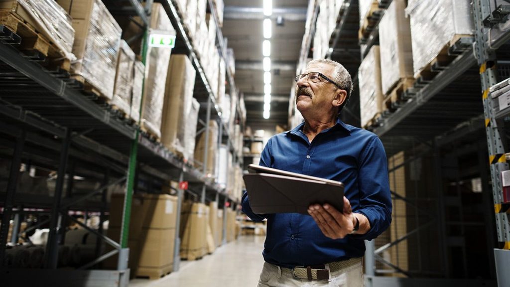 man reviewing inventory levels in a warehouse