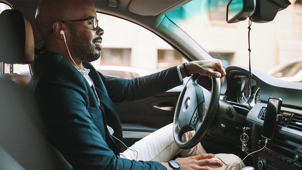 Smiling man driving in a car.
