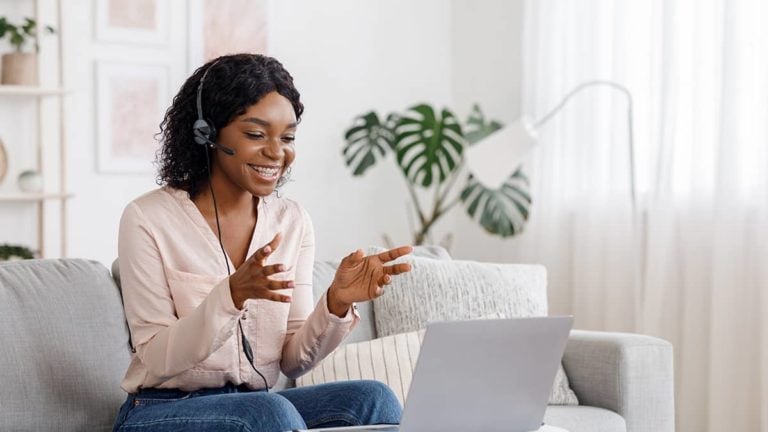 woman having a virtual meeting with out-of-state remote workers in her living room