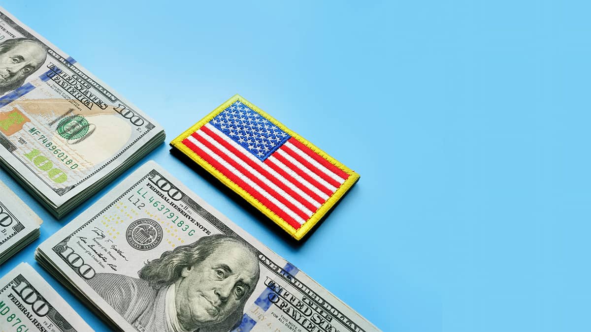 flag pin and money on blue background representing support for veteran-owned small business