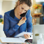 Woman on the phone looking at a document.