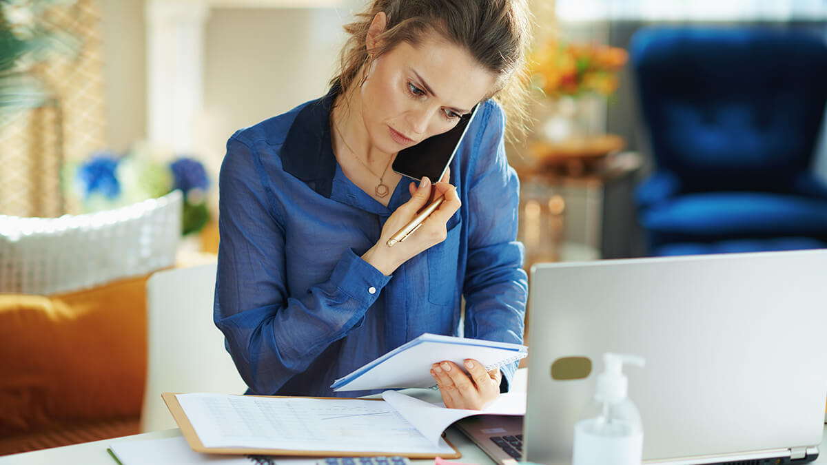 Woman on the phone looking at a document.