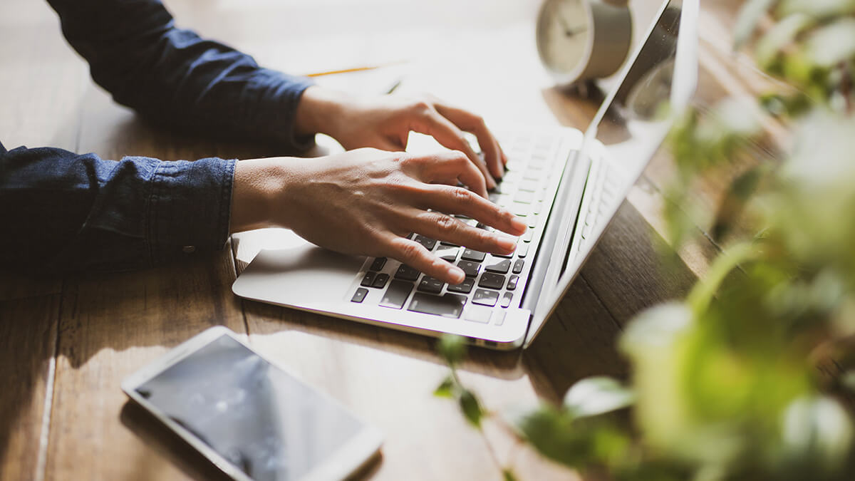 Business owner's hands on a laptop.