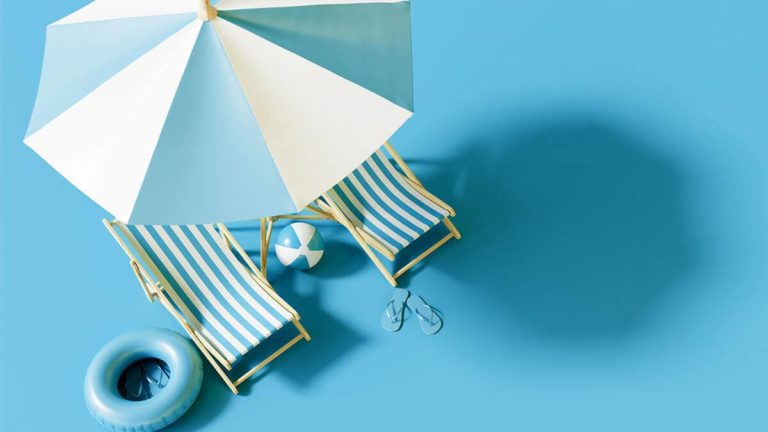 Two miniature beach chairs under an umbrella.