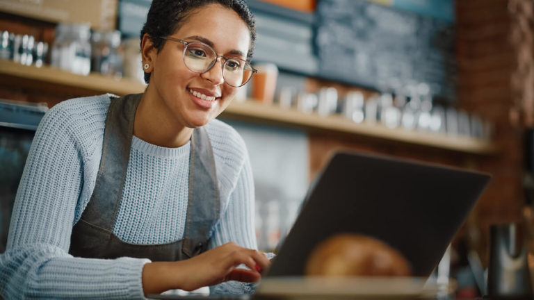 Woman managing digital payments in her cafe.