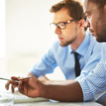 Two men discussing business estimates.