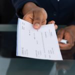 Employer handing a paycheck to an employee.