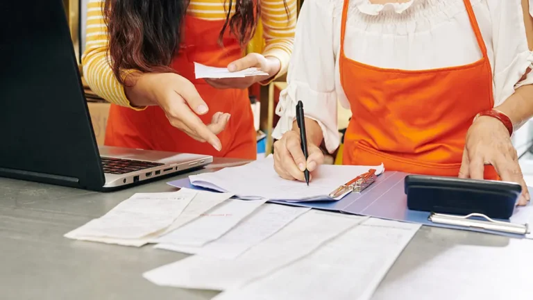 Business owner and employee correcting payroll overpayment