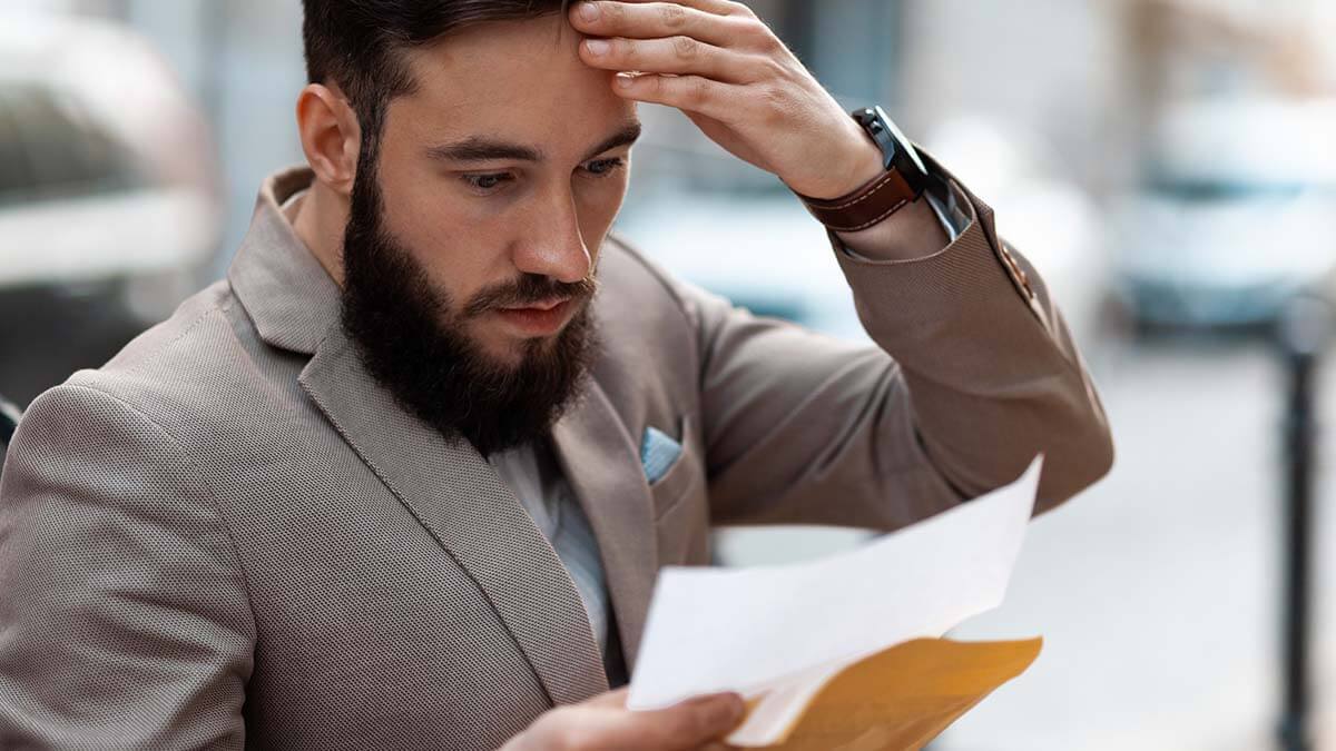 Stressed man reading failure-to-file penalty.
