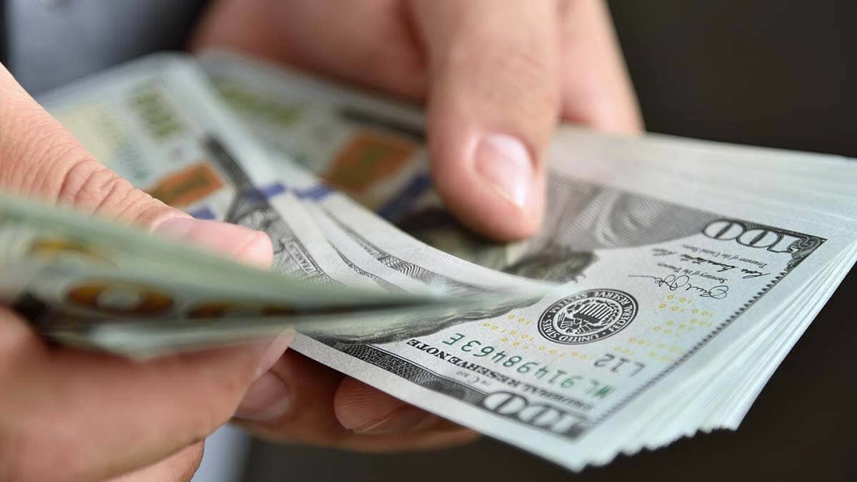 $100 bills in hands.