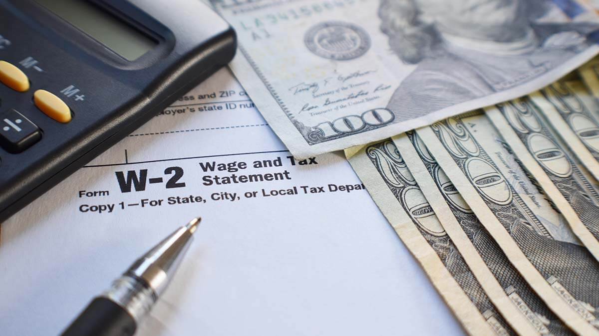 Form W-2, calculator, pen, and bills.