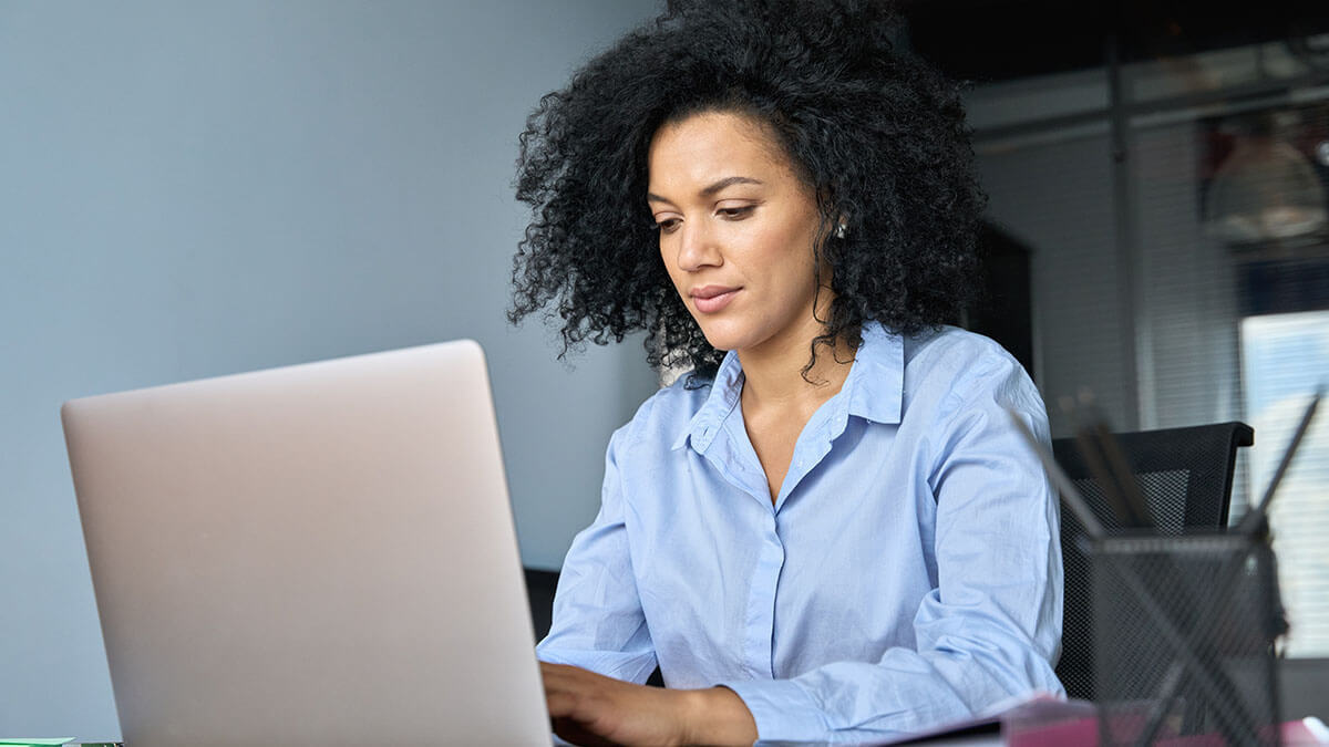 Woman typing on a laptop.