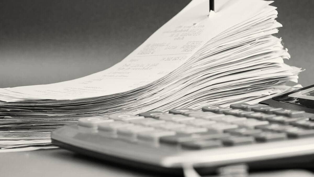 Stack of receipts next to a calculator.