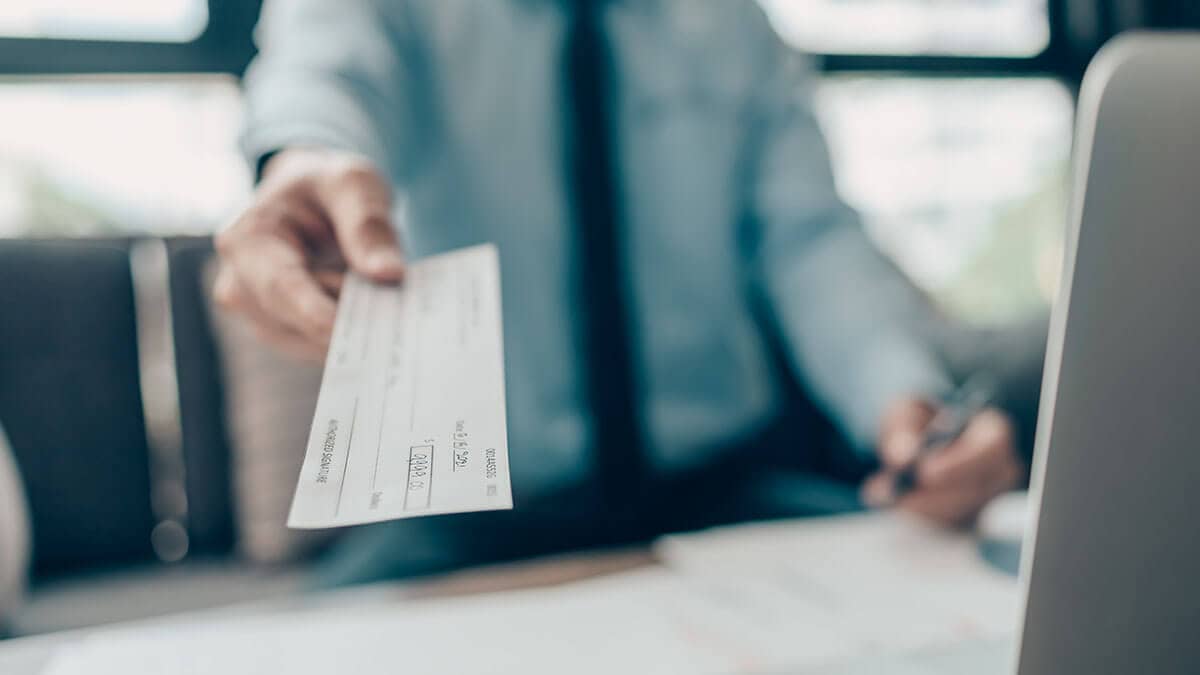 Employer handing employee an earned wage access check.