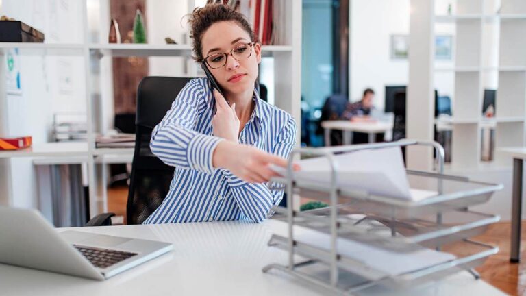 Accountant putting a piece of paper in a tray.