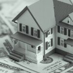 Miniature house on bills.