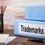 Binder that says "Trademarks" next to a cup of pencils.