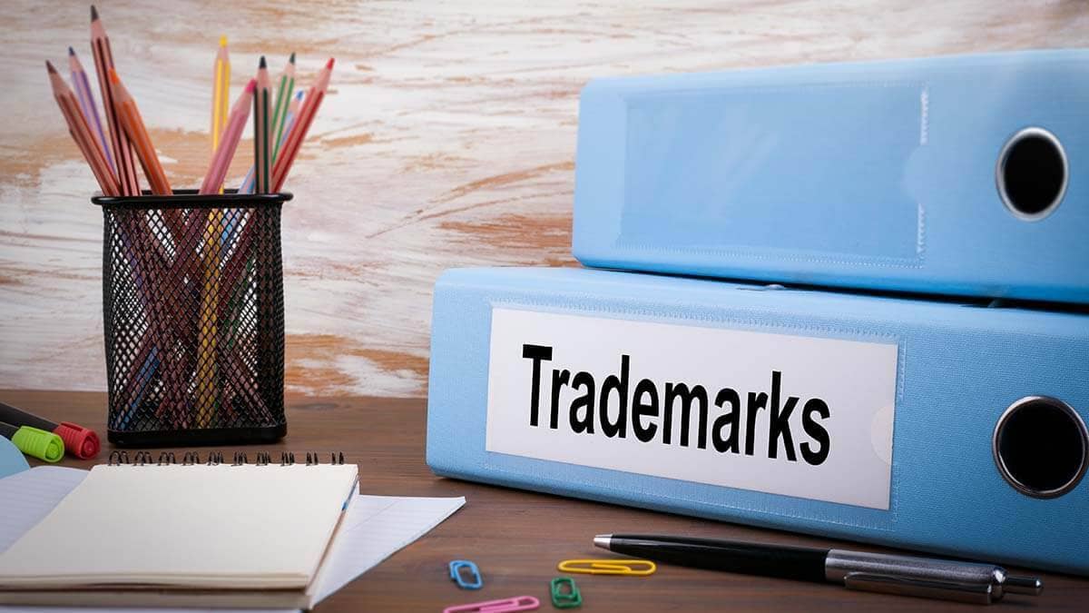 Binder that says "Trademarks" next to a cup of pencils.