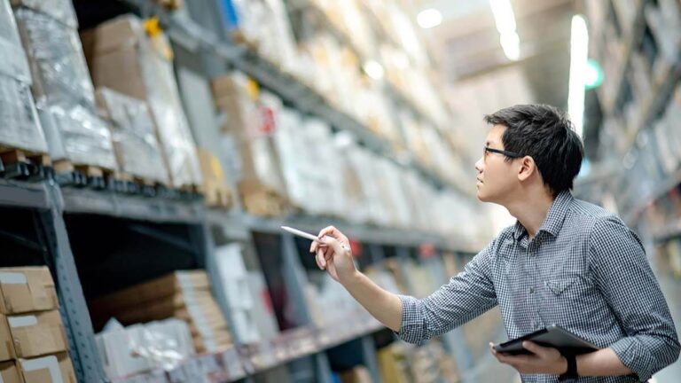 Business owner taking inventory in warehouse.