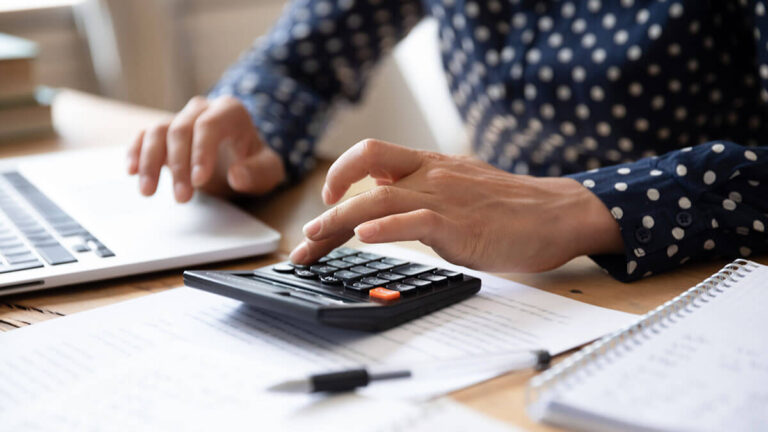 Woman using a calculator and researching accounting trends.