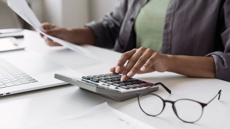 Woman using a calculator at her desk.